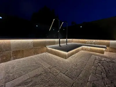 a stone bench with a statue on it at night at Aquamarine Jaz Montenegro in Budva