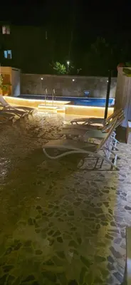 a group of lounge chairs and a surfboard in the water at Aquamarine Jaz Montenegro in Budva