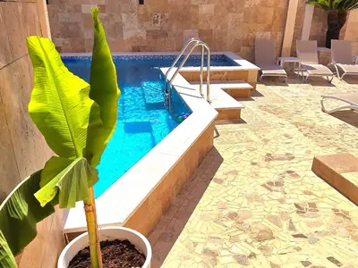 a plant in a pot next to a swimming pool at Aquamarine Jaz Montenegro in Budva