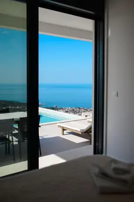 a room with a view of a pool and a table at Green Hills Villa in Bar