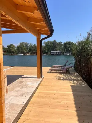 a wooden dock with benches on the water at Gold fish3 in Ulcinj