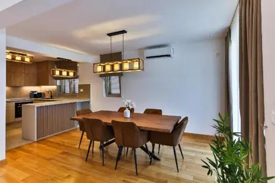 a kitchen and dining room with a wooden table and chairs at Luxury Apartments Przno in Budva