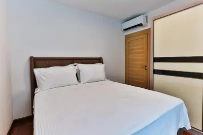 a bedroom with a white bed and a brown door at Luxury Apartments Przno in Budva