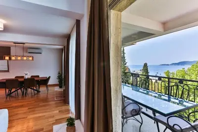 a room with a balcony with a view of the ocean at Luxury Apartments Przno in Budva
