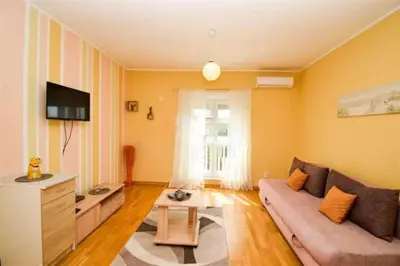 a living room with a couch and a tv at Charming studio in Podgorica