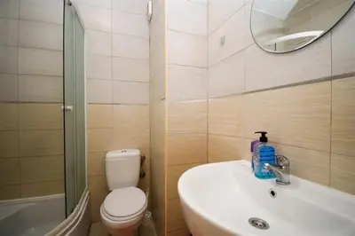 a bathroom with a toilet and a sink and a mirror at Charming studio in Podgorica