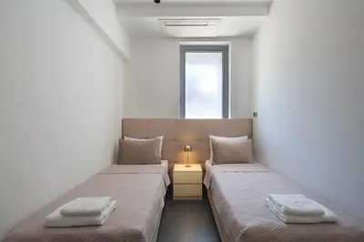 two beds in a room with a lamp between them at Torch Apartments in Budva