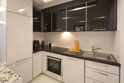 a kitchen with white cabinets and a sink at Torch Apartments in Budva