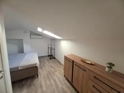 a bedroom with a bed and a wooden dresser at Amelia in Radanovići