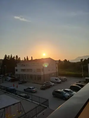 a parking lot with cars parked in front of a building at Amelia in Radanovići
