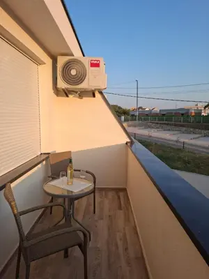 a small table and chair on a balcony with a speaker at Amelia in Radanovići