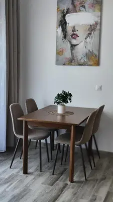 a dining room table with chairs and a painting at Amelia in Radanovići