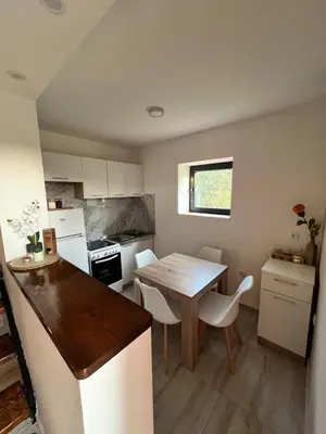 a small kitchen with a wooden table and chairs at Salty Olives in Ulcinj
