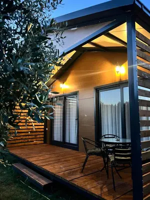 a wooden deck with a table and chairs on it at Salty Olives in Ulcinj