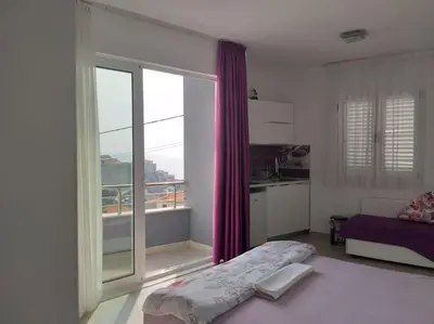 a bedroom with a bed and a large window at Sea Violet in Ulcinj