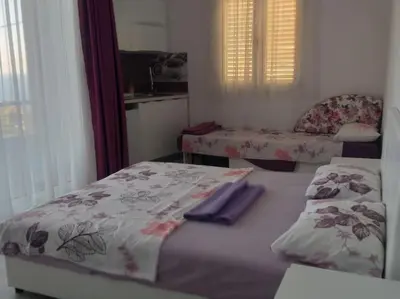 a small bedroom with a bed and a chair at Sea Violet in Ulcinj