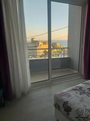 a bedroom with a large window with a view of a city at Sea Violet in Ulcinj