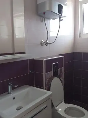 a bathroom with a white toilet and a sink at Sea Violet in Ulcinj