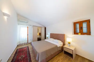 a small bedroom with a bed and a table at Villa Olive Grove in Budva