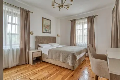 a bedroom with a bed and a desk and windows at Villa Olive Grove in Budva