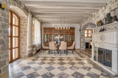 a dining room with a fireplace and a table and chairs at Villa Olive Grove in Budva