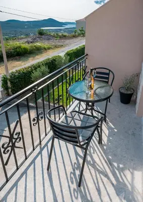 a table and chairs on a balcony with a view of the ocean at Appartement en Chêne in Kotor