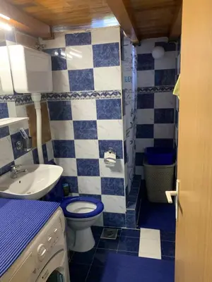 a blue and white bathroom with a toilet and a sink at Apartman Tina Gurdić in Kotor