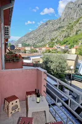 a balcony with a table and a view of a mountain at Apartman Tina Gurdić in Kotor