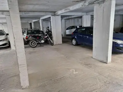 a parking garage with cars and a motorcycle in it at Modern comfort free parking in Budva