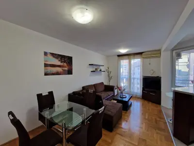 a living room with a couch and a glass table at Modern comfort free parking in Budva
