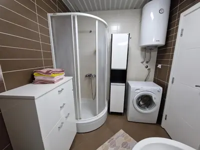 a bathroom with a shower and a washing machine at Modern comfort free parking in Budva