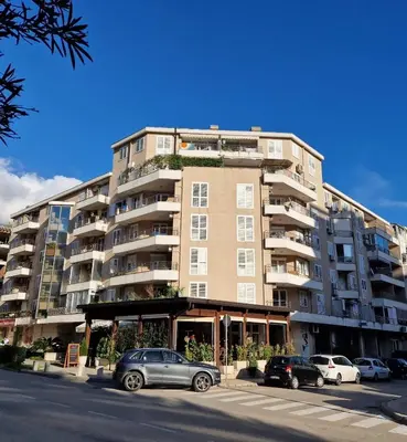 a large building with cars parked in front of it at Modern comfort free parking in Budva