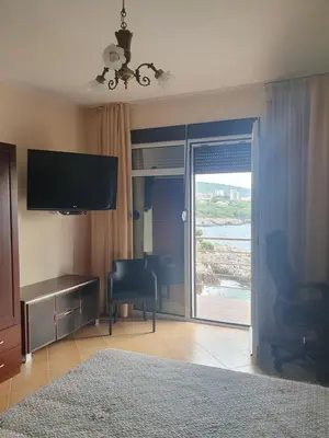 a living room with a television and a sliding glass door at Aurora Spa in Kunje
