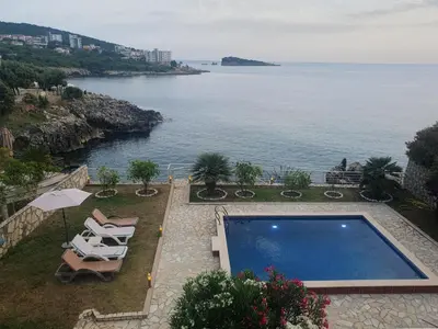 a swimming pool with chairs and a view of the ocean at Aurora Spa in Kunje
