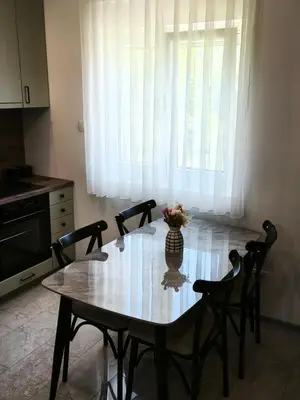 a dining room table with a vase of flowers on it at DIS LUX Apartments in Radanovići