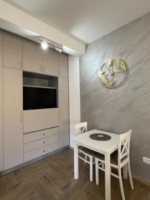 a dining room with a white table and a tv at DIS LUX Apartments in Radanovići