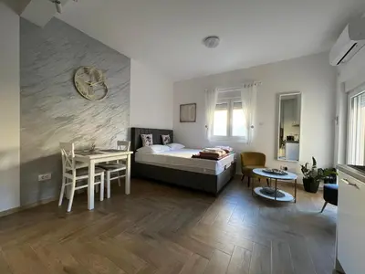 a bedroom with a bed and a table and chairs at DIS LUX Apartments in Radanovići