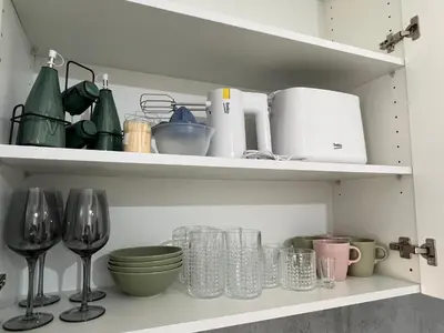 a shelf with wine glasses and other kitchen utensils at DIS LUX Apartments in Radanovići