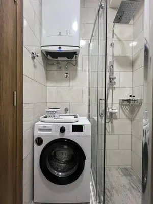a washing machine in a bathroom with a shower at DIS LUX Apartments in Radanovići