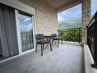 a patio with a table and chairs on a balcony at DIS LUX Apartments in Radanovići
