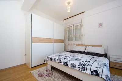 a bedroom with a bed and a glass wall at Sea view Lazi in Budva