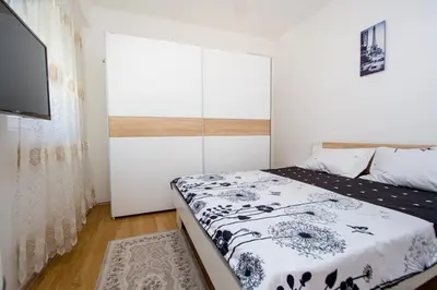 a small bedroom with a bed and a television at Sea view Lazi in Budva