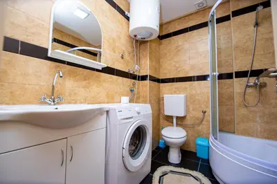 a bathroom with a washing machine and a toilet at Sea view Lazi in Budva