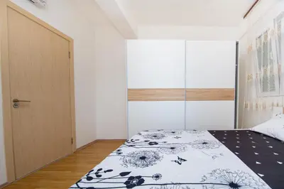 a bedroom with a bed with a black and white blanket at Sea view Lazi in Budva