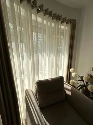 a couch sitting in front of a window with curtains at Exclusive Apartments in Ulcinj
