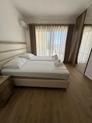 a bedroom with two beds and a large window at Exclusive Apartments in Ulcinj