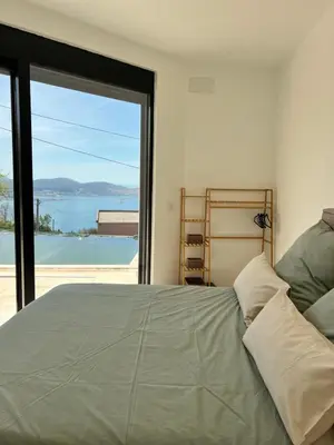 a bedroom with a bed and a large window at Villa Infinity Bar Montenegro in Brca