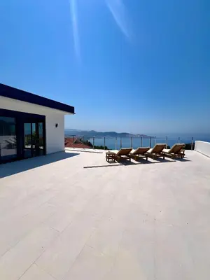 a row of benches on a patio overlooking the ocean at Villa Infinity Bar Montenegro in Brca
