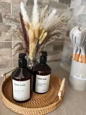 two bottles ofnatural soap sitting on a wicker basket at Villa Infinity Bar Montenegro in Brca