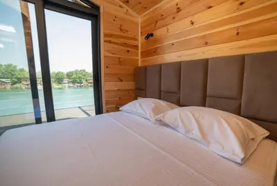 a bedroom with a large bed with a large window at Villa Boga on Ada Bojana in Gornji Štoj